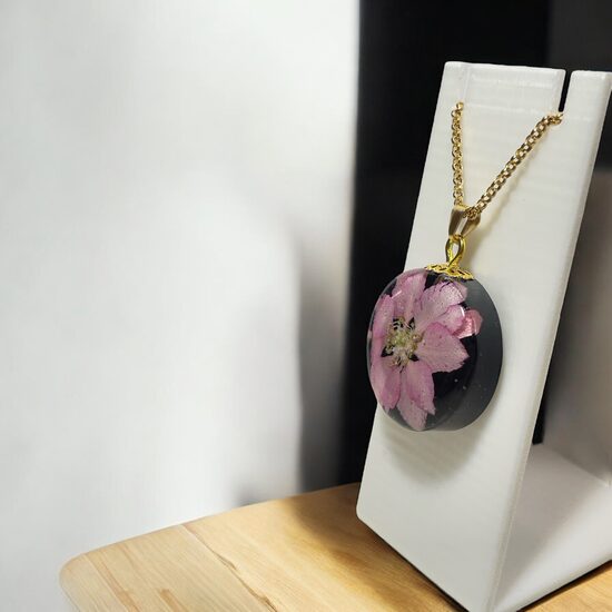 Kulons ar rozā ziedu